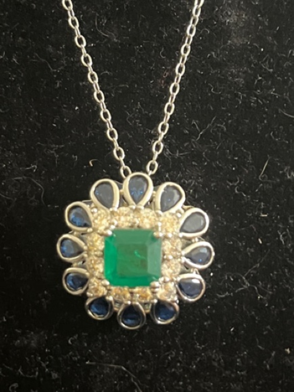 Stunning pendant featuring the look of sapphire, diamond and emerald.